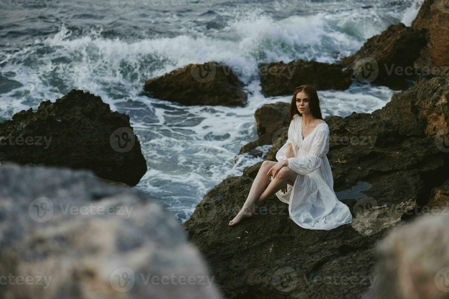 donna nel bianca vestito natura viaggio bagnato capelli scogliera foto