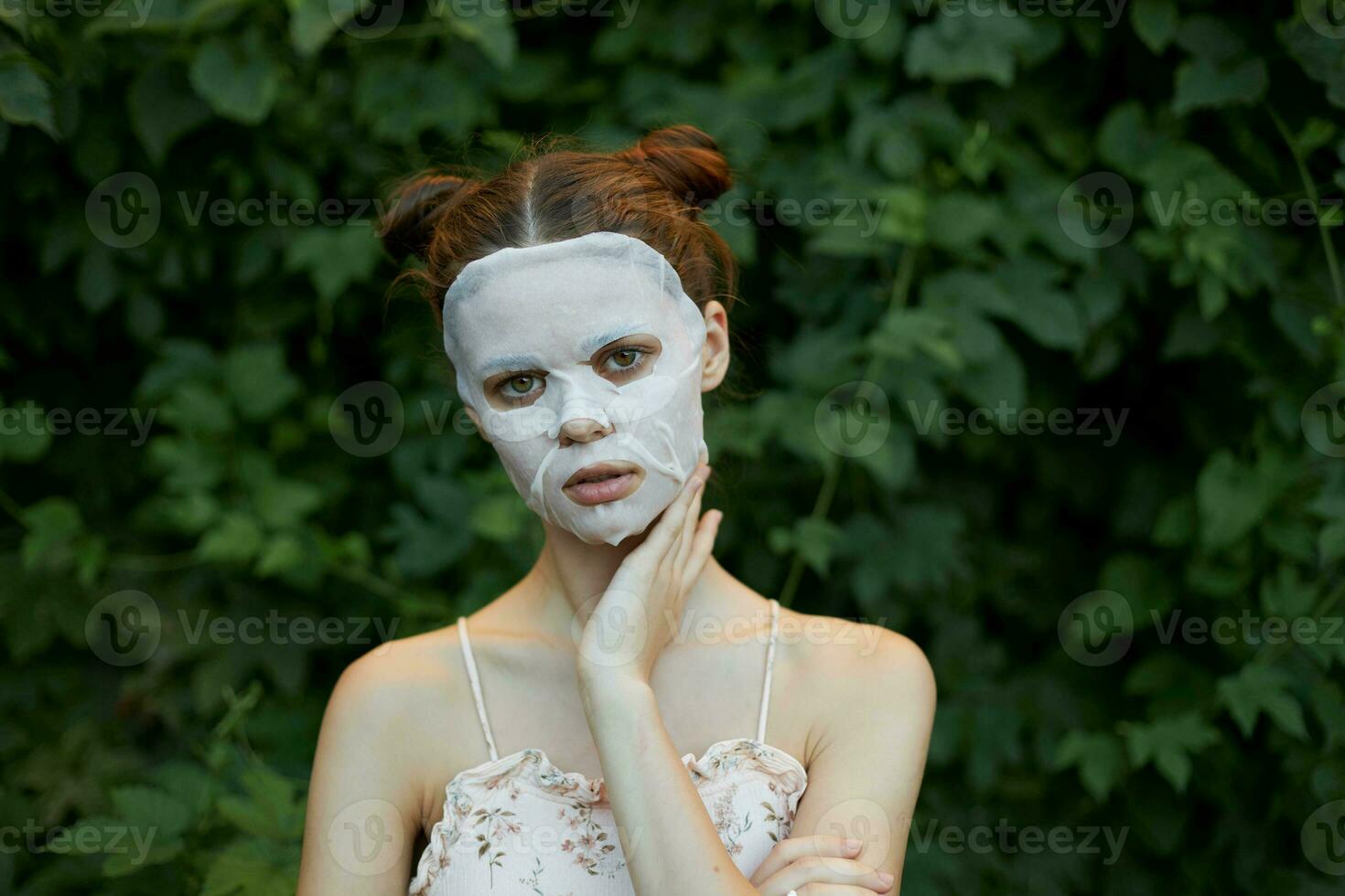 bellissimo donna bianca maschera cosmetologia verde cespugli nel il sfondo copia spazio foto