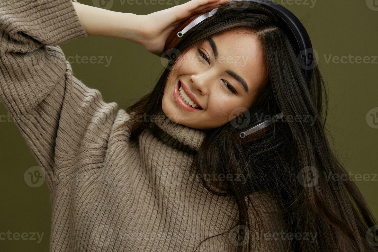 brunetta nel un' maglione ascoltando per musica con cuffie divertimento isolato sfondo foto