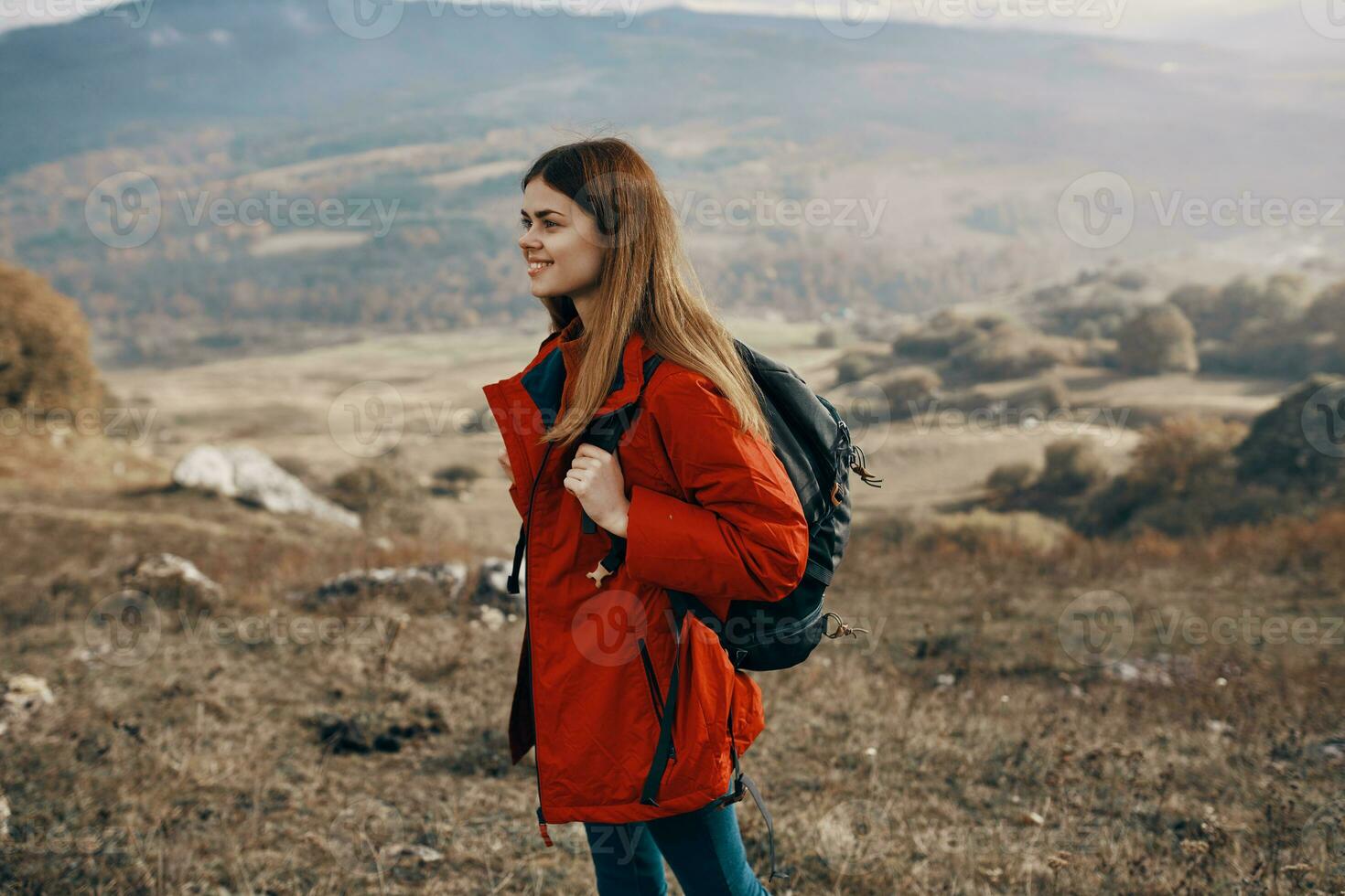 dai capelli rossi donna nel giacca con zaino viaggio escursioni a piedi montagne fresco aria foto