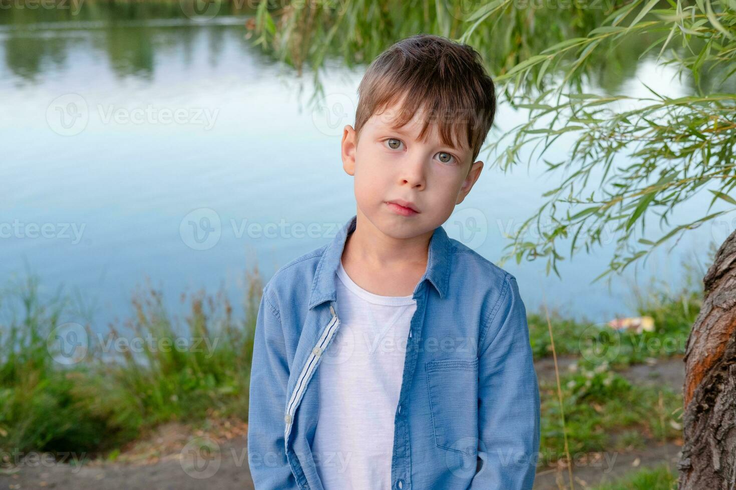 ritratto di un' carino ragazzo su il sfondo di il lago nel il parco foto