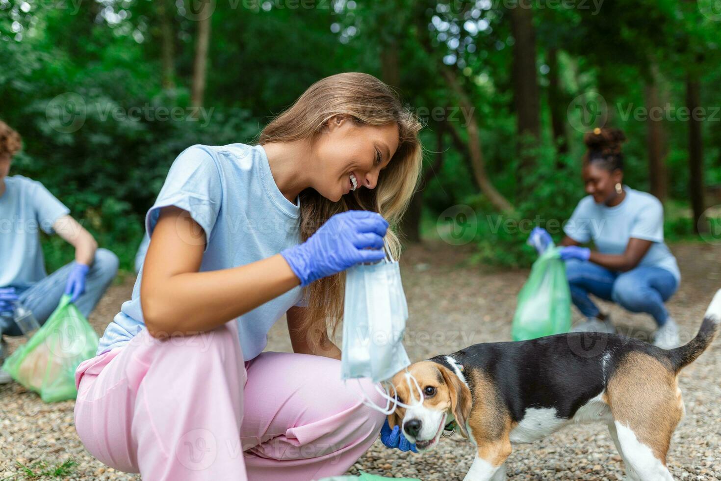 giovane donna con sua cane rifiuto collettore occupato separare medico o ppe rifiuto a partire dal plastica spazzatura durante il covid-19 coronavirus pandemia foto