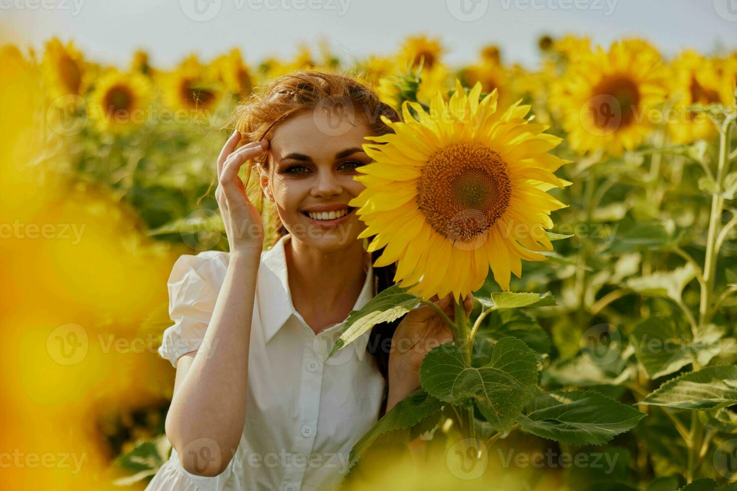 donna con Due trecce nel un' bianca vestito ammira natura fioritura impianti foto