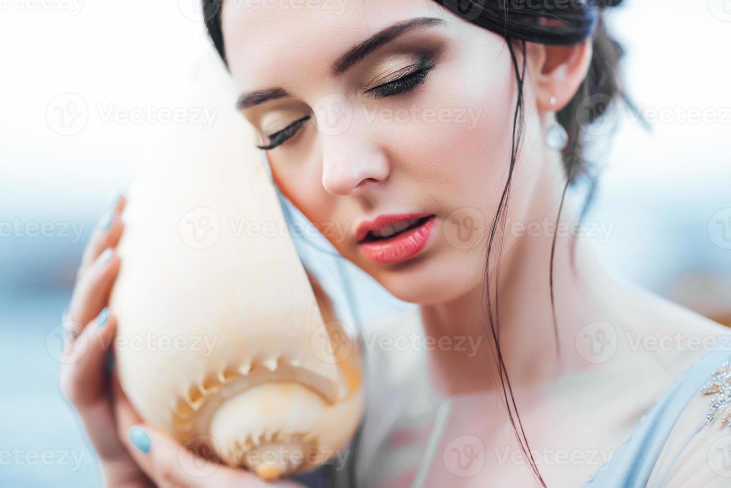 sposa con una grande conchiglia sulla spiaggia foto