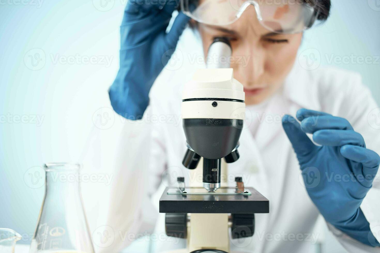 donna nel laboratorio guardare attraverso microscopio avvicinamento biotecnologia scienza foto