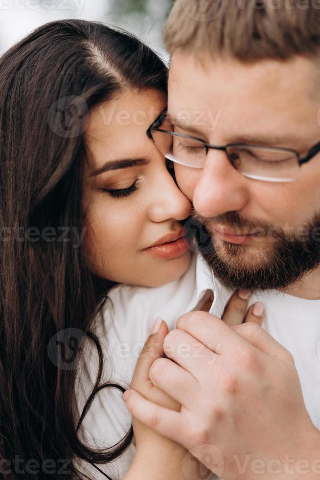 giovane coppia innamorata di un ragazzo con la barba e una ragazza con i capelli scuri in abiti leggeri foto