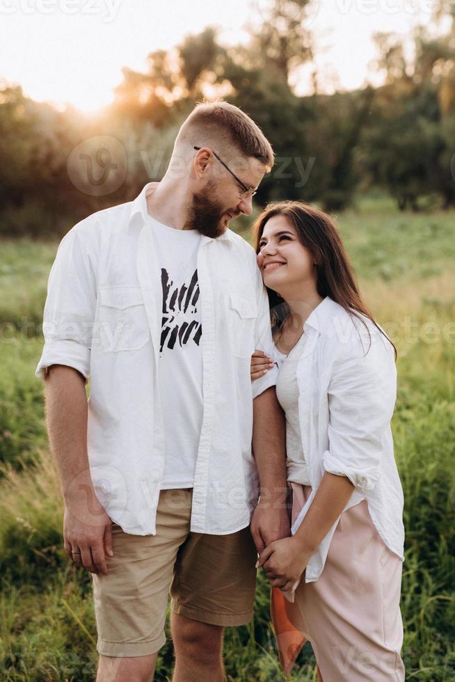 giovane coppia innamorata di un ragazzo con la barba e una ragazza con i capelli scuri in abiti leggeri foto