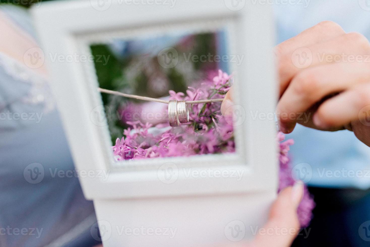 lo sposo veste la sposa con fedi nuziali foto