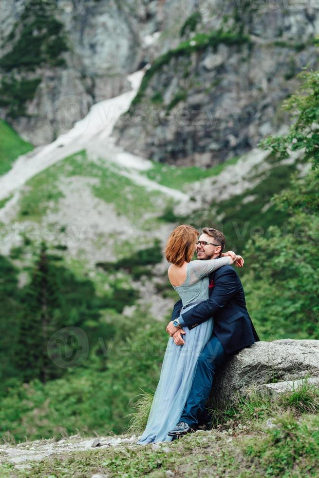 giovane coppia in una passeggiata vicino al lago circondato dalle montagne foto