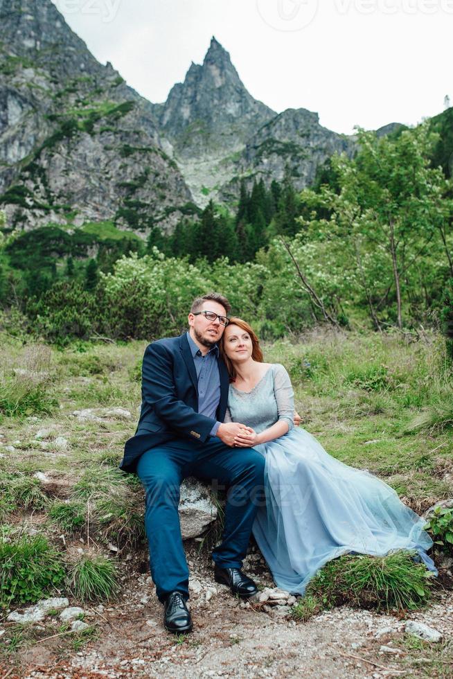 giovane coppia in una passeggiata vicino al lago circondato dalle montagne foto