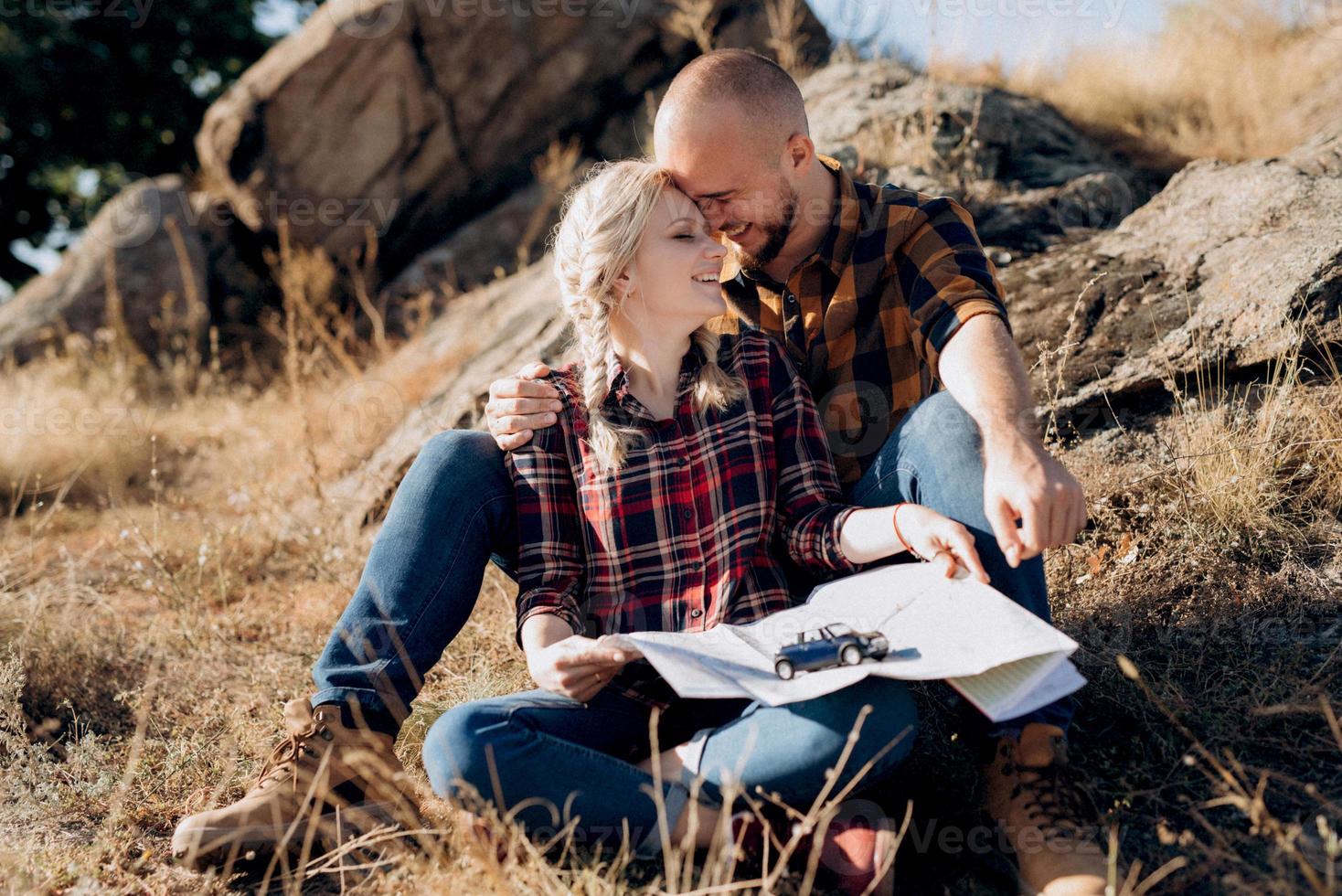 ragazzo calvo con la barba e una ragazza bionda stanno guardando la mappa e cercando foto