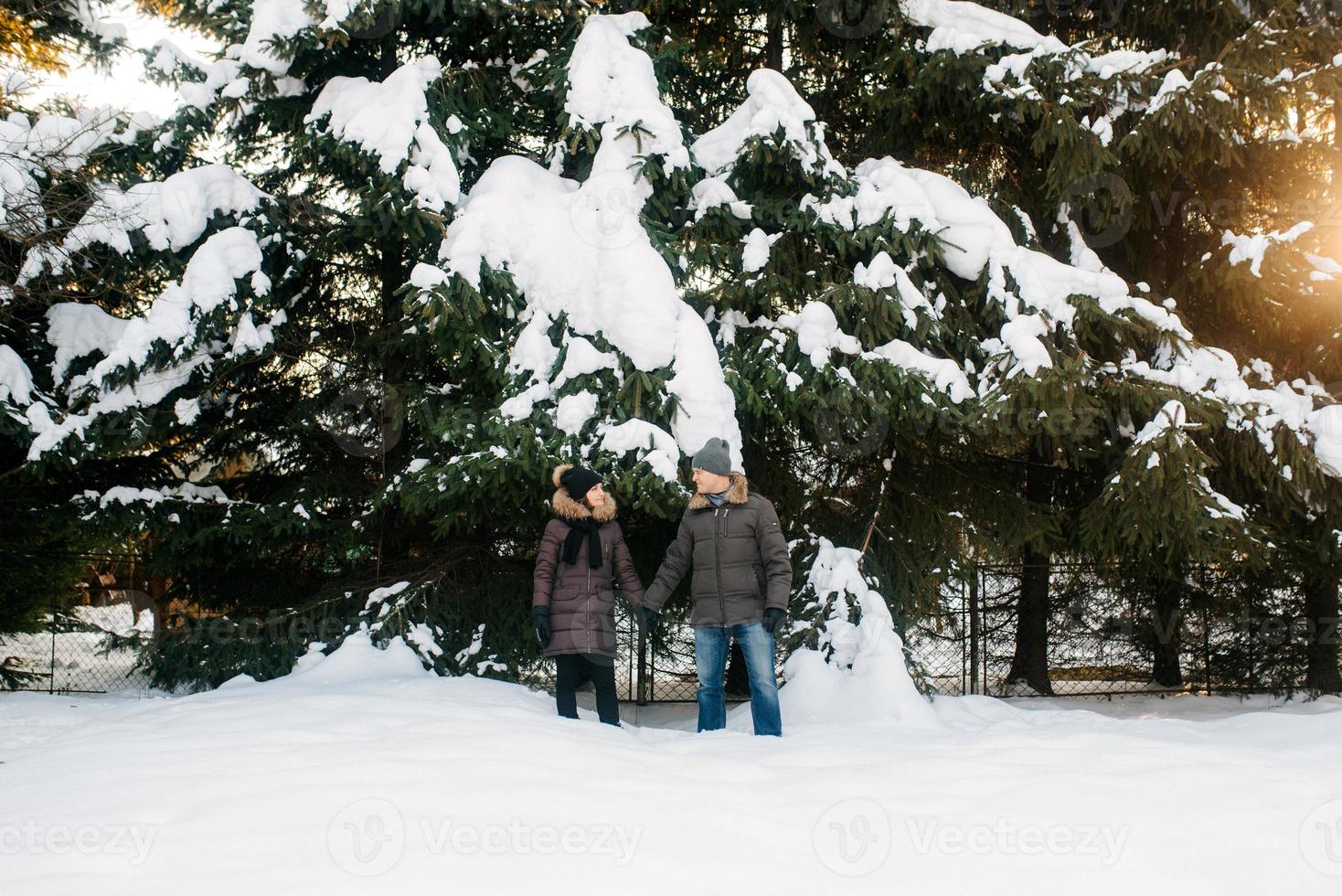 ragazzo e ragazza all'aperto durante una passeggiata invernale giocando a palle di neve foto