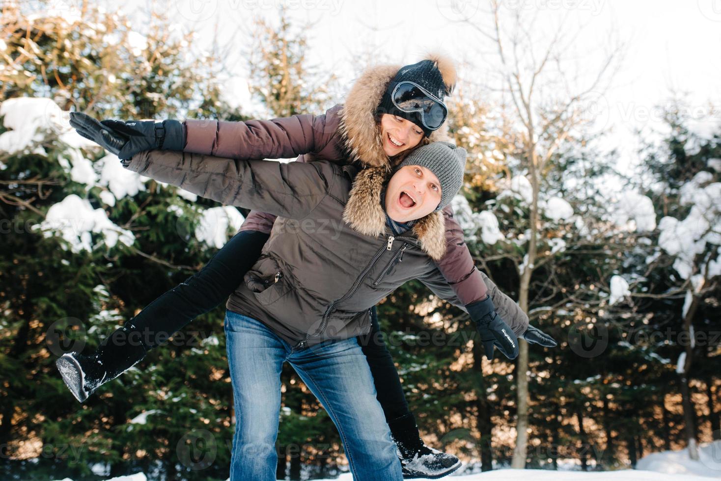 ragazzo e ragazza all'aperto durante una passeggiata invernale giocando a palle di neve foto