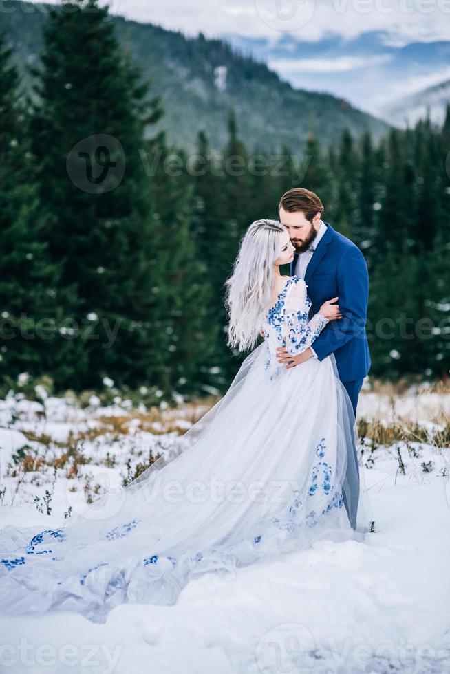 sposo in abito blu e sposa in bianco nei Carpazi foto