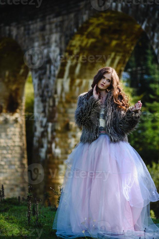 la sposa cammina sotto un ponte foto