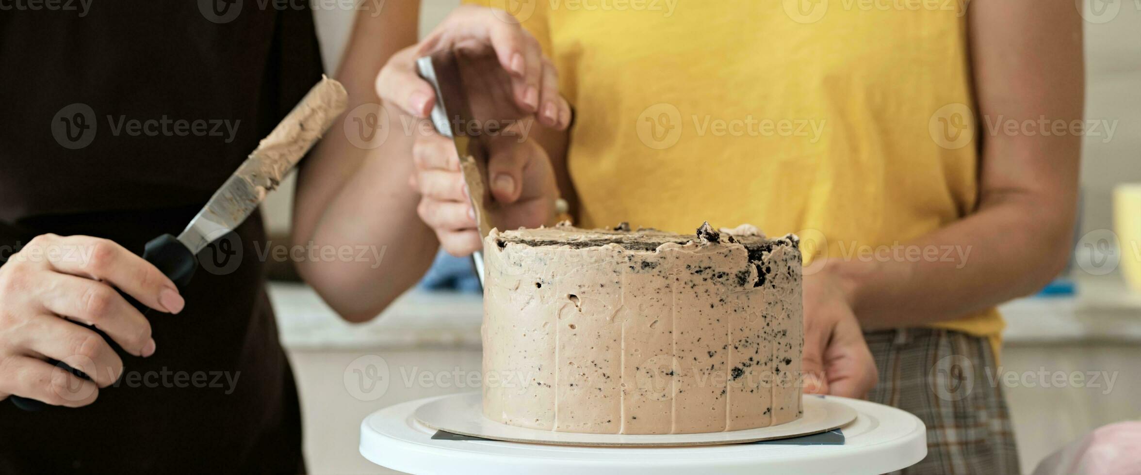 donne coppia fabbricazione cioccolato torta nel cucina, avvicinamento. torta fabbricazione processi, selettivo messa a fuoco, bandiera formato foto