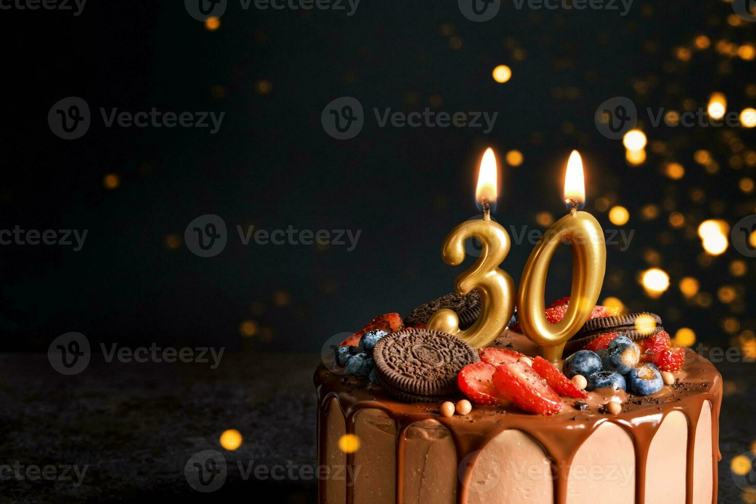 cioccolato compleanno torta con frutti di bosco, biscotti e numero trenta d'oro candele su nero sfondo, copia spazio foto