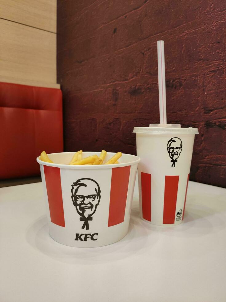 stavropoli, Russia - aprile 2023 kfc veloce cibo ristorante. un' bicchiere di frappè e un' scatola di francese patatine fritte In piedi su un' tavolo dentro un' ristorante foto