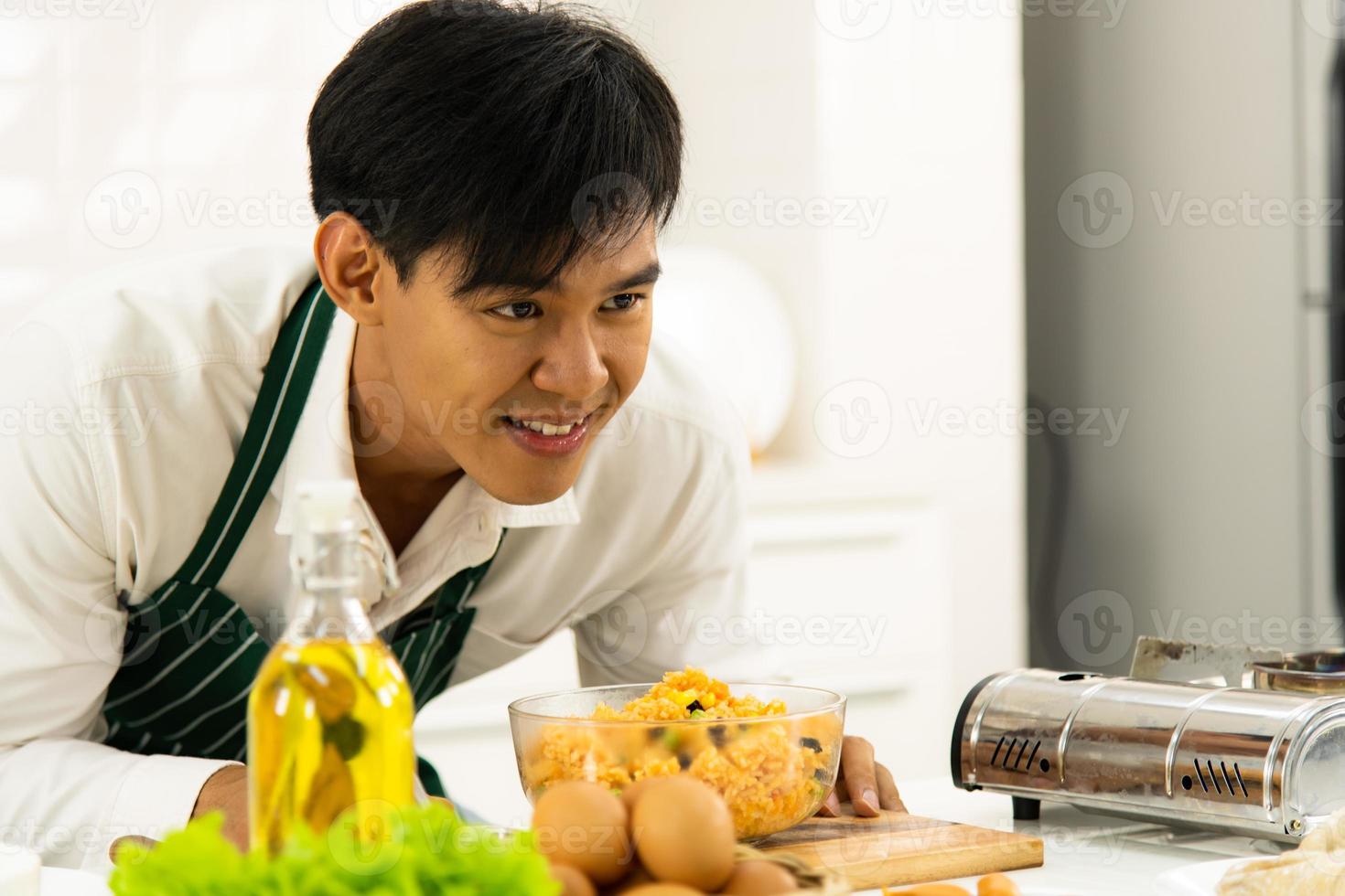 chef maschio asiatico che cucina riso fritto in cucina foto