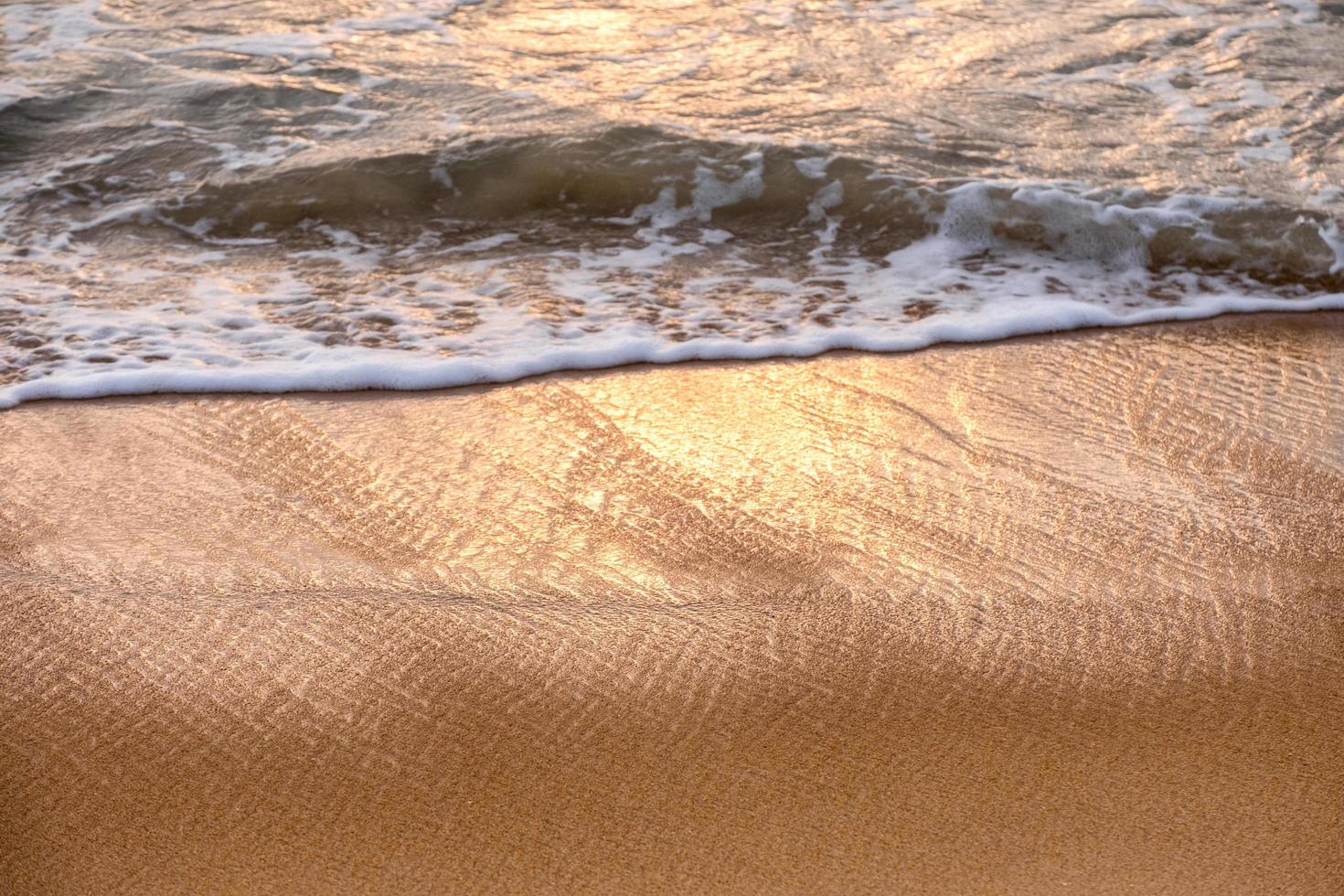 onda di mare tropicale lucido con bolla sulla spiaggia marrone al tramonto foto
