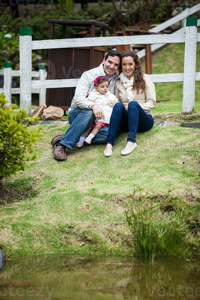 giovane genitori avendo divertimento all'aperto con loro uno anno vecchio bambino ragazza. felicità concetto. famiglia concetto foto