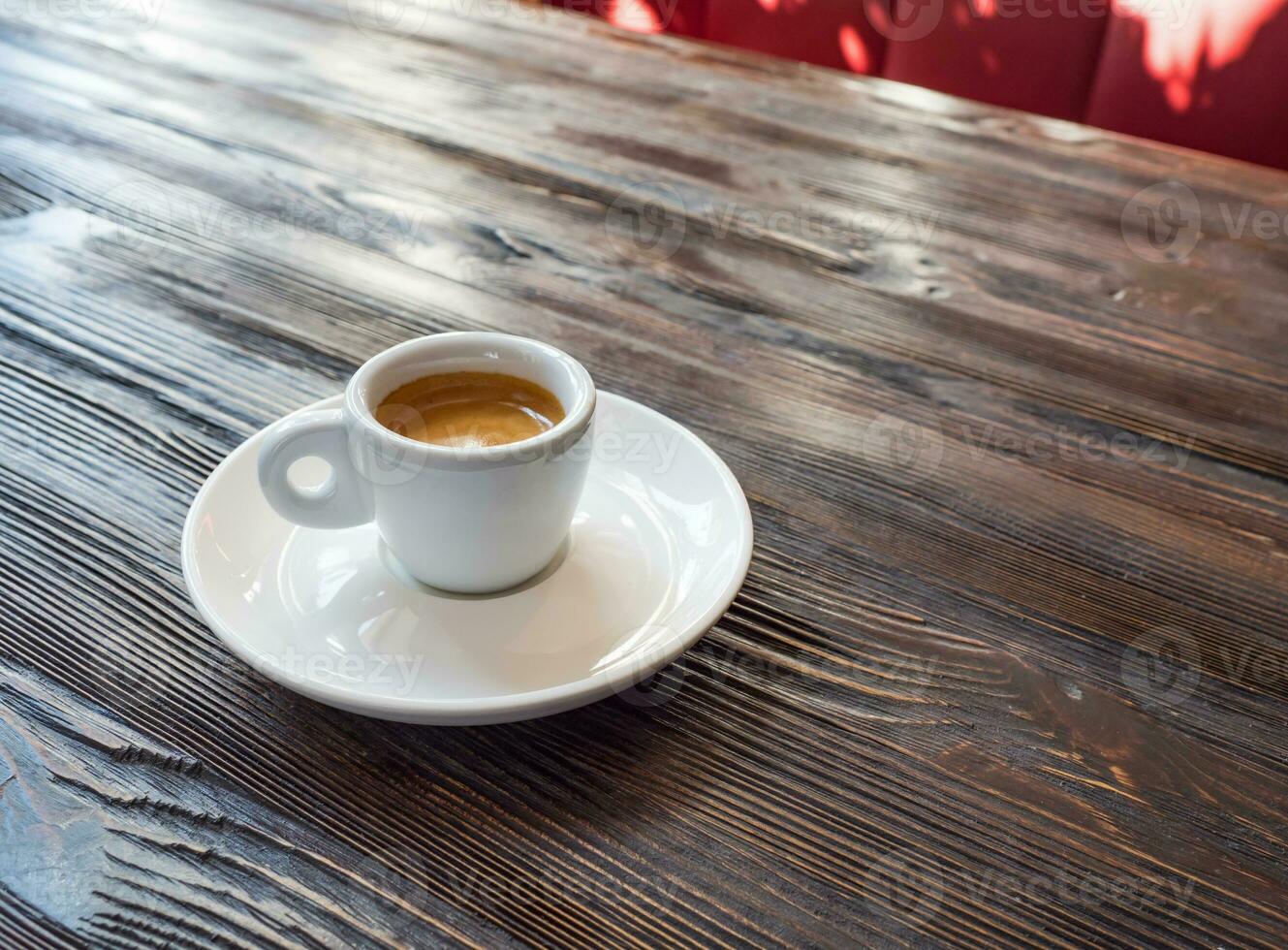 caffè espresso tazza su un' di legno tavolo nel il interno di il bar foto