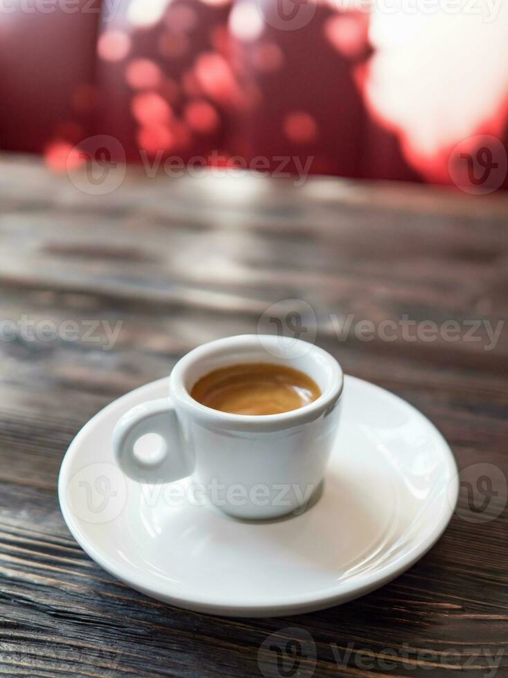 caffè espresso tazza su un' di legno tavolo nel il interno di il bar foto