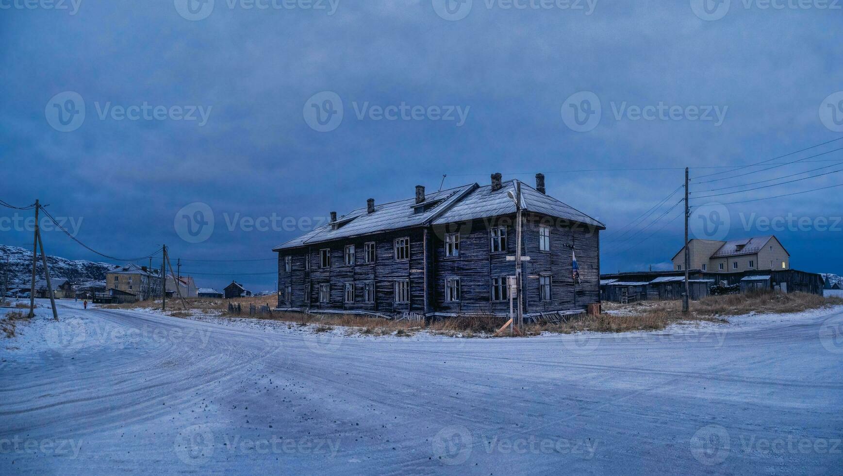 il blu ora. Vintage ▾ case su il sfondo di innevato artico colline. vecchio autentico villaggio di teriberka. foto