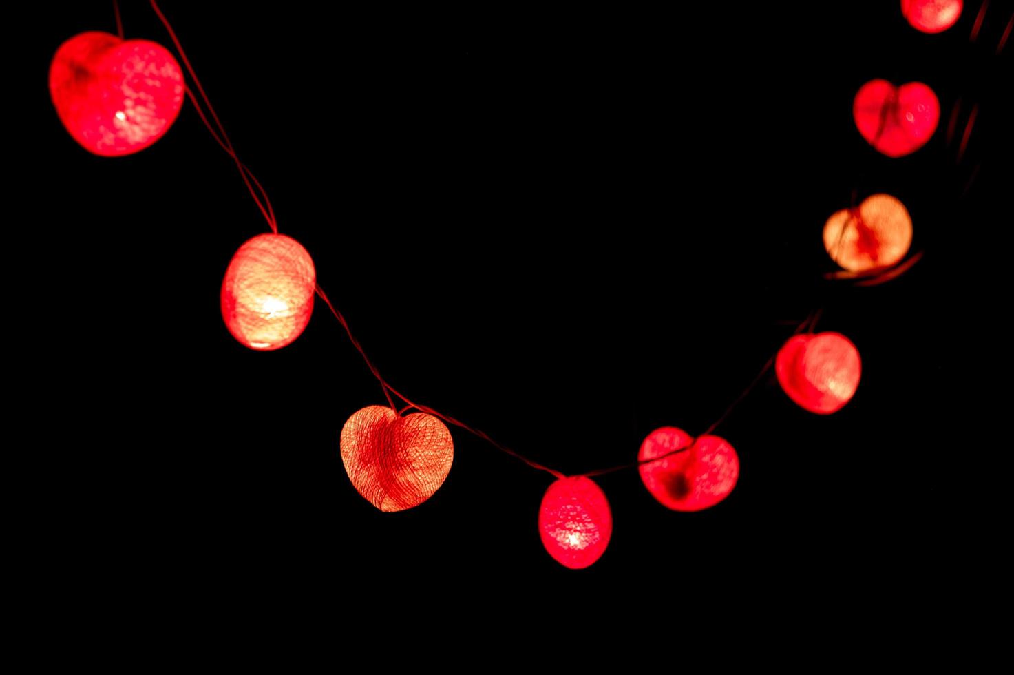 primo piano luci a led a forma di cuore in camera oscura foto