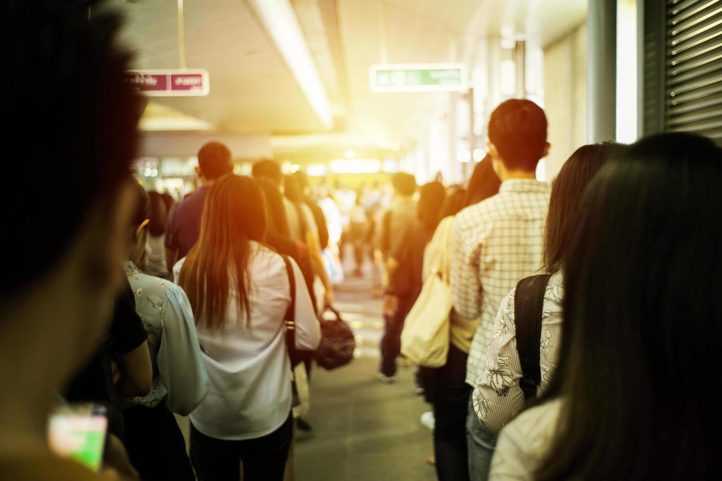 indietro ritratto folla di persone in attesa del treno al binario della stazione foto