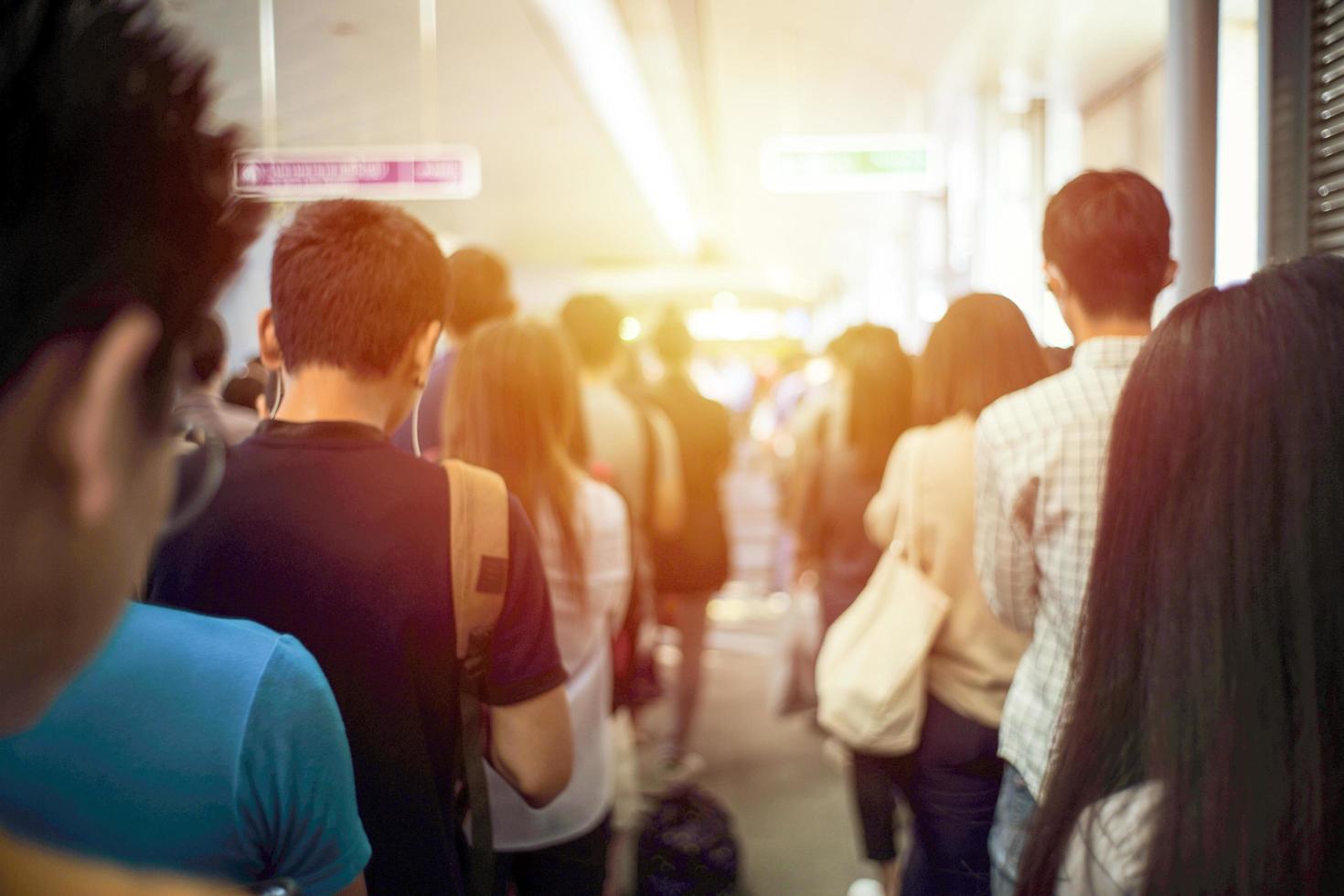 indietro ritratto folla di persone in attesa del treno al binario della stazione foto