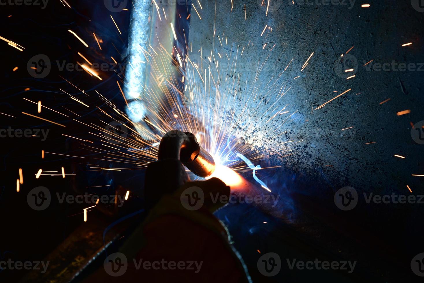 saldatore, o artigiano, che erige acciaio tecnico industriale in fabbrica foto