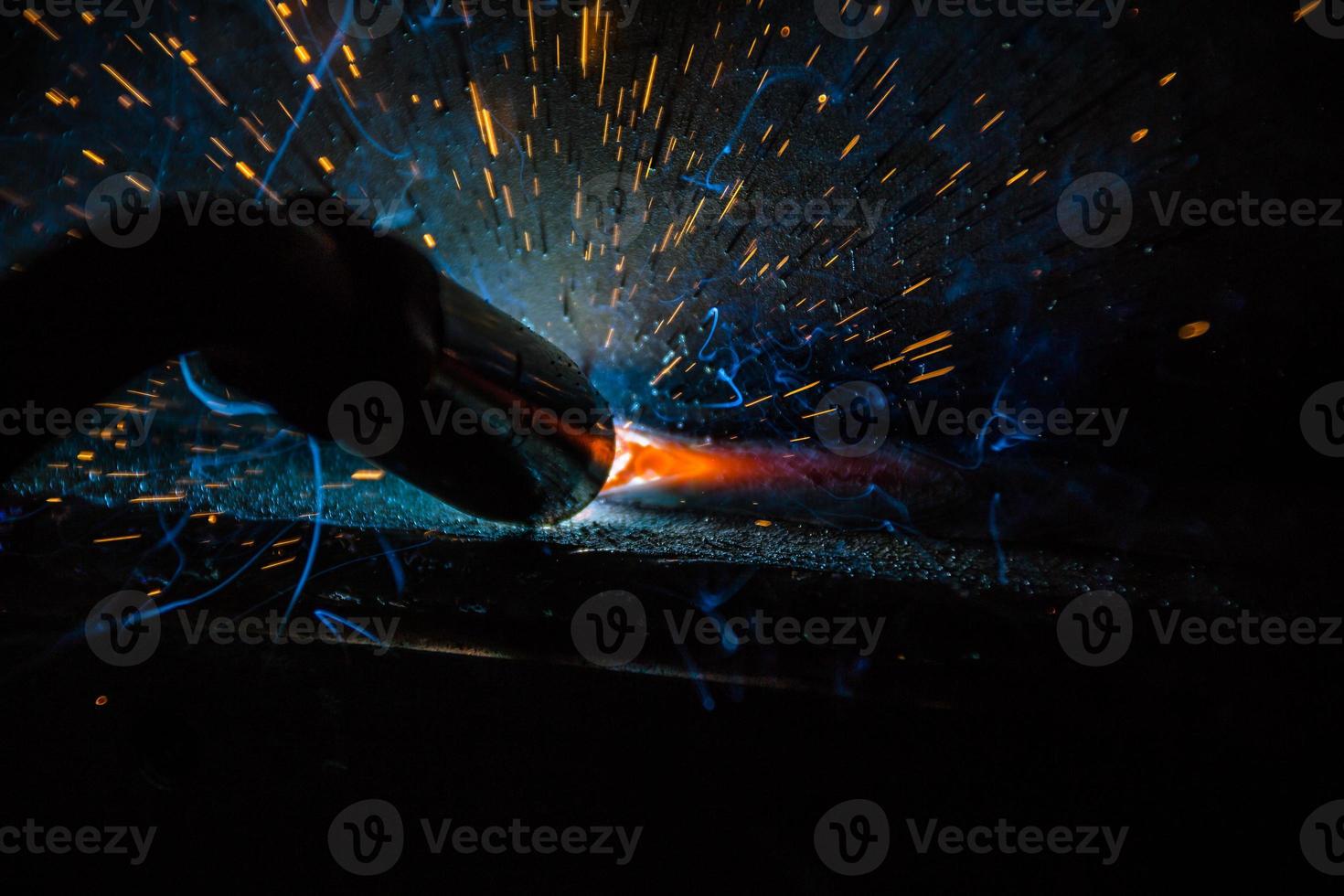 saldatore, o artigiano, che erige acciaio tecnico industriale in fabbrica foto