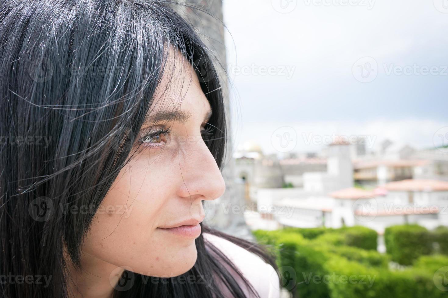 primo piano di una donna che guarda una città foto