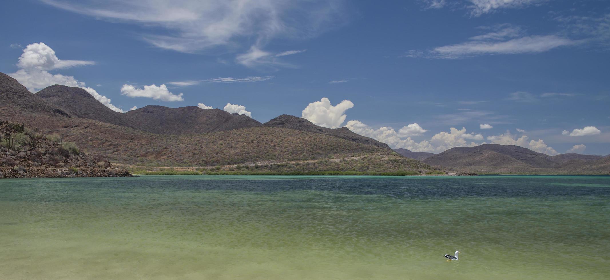 El Requeson spiaggia circondata da montagne nuvola e blu cielo soleggiato a Bahia Concepcion Baja California sur Mulege Messico foto