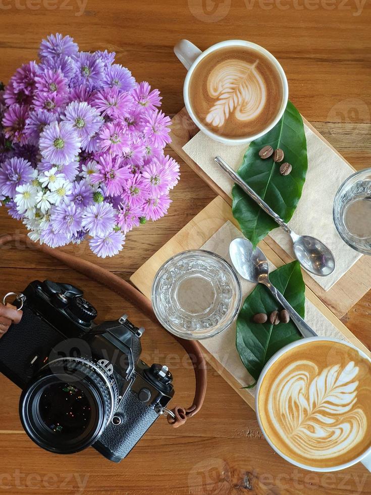 vista dall'alto di una tazza di caffè con fagioli su fondo in legno. foto