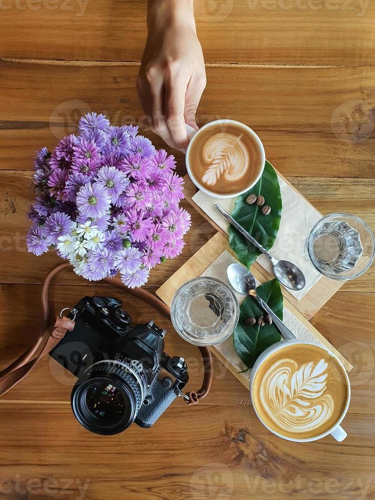 vista dall'alto di una tazza di caffè con fagioli su fondo in legno. foto