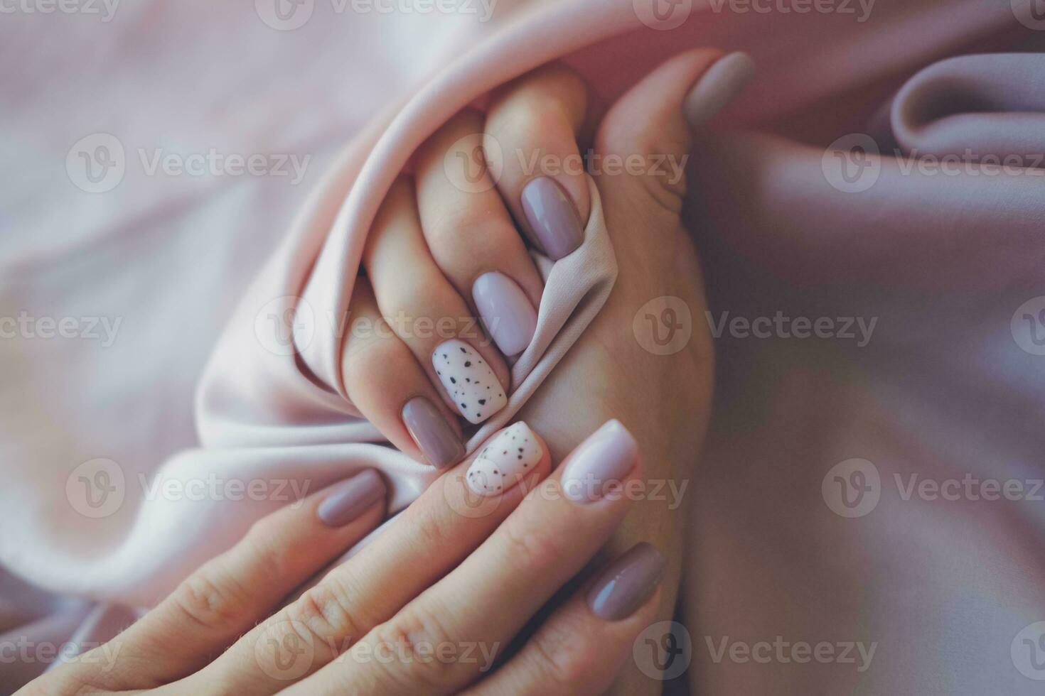 donne - mani con bellissimo manicure su un' sfondo di seta tessuto. autunno tendenza, polacco il beige e Quaglia modello su il Chiodi con gel polacco, Gommalacca. copia spazio. foto