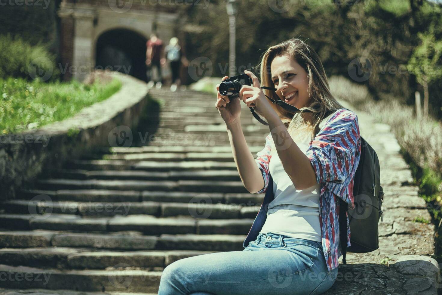 giovane turista donna seduta di il le scale assunzione fotografie