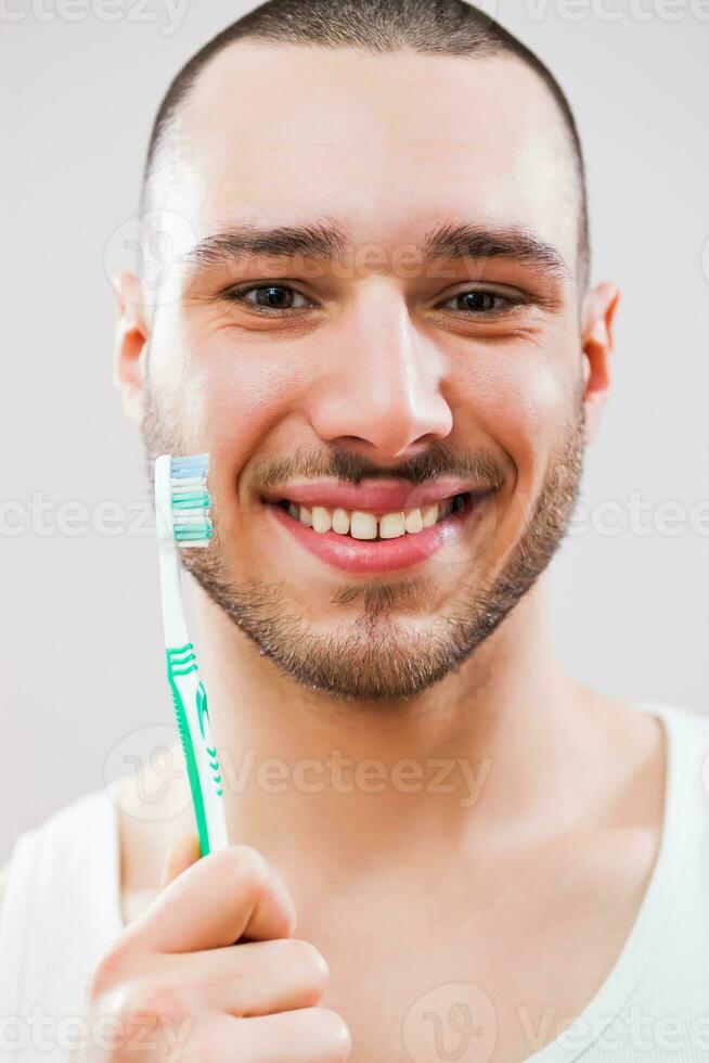 un' uomo chi prende cura di il suo denti foto