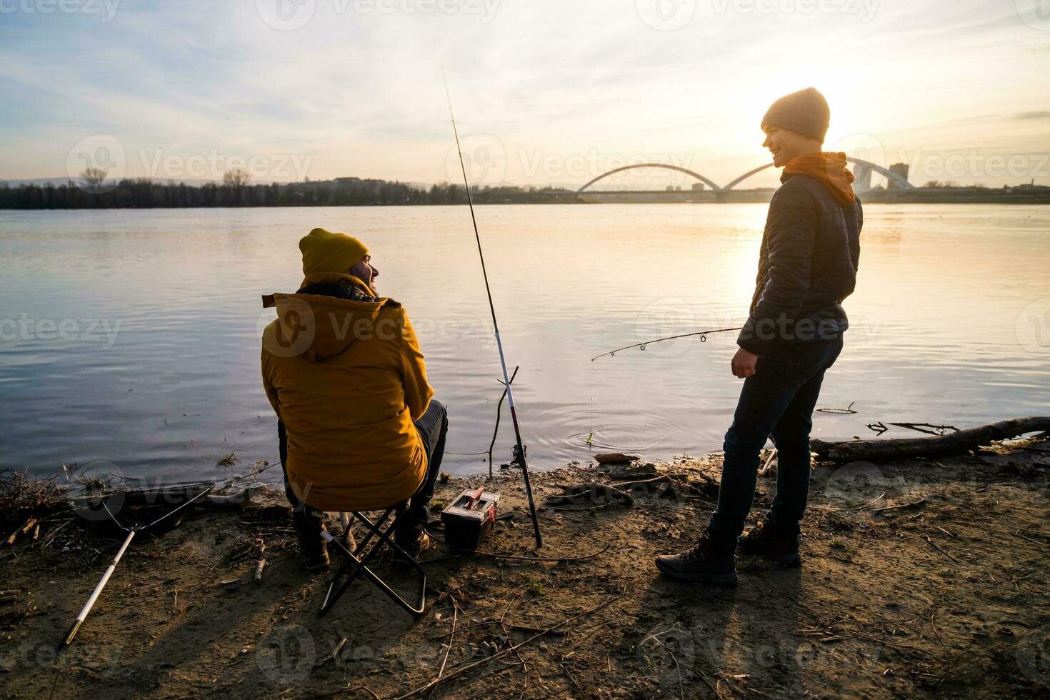 padre e figlio siamo pesca su soleggiato inverno giorno foto