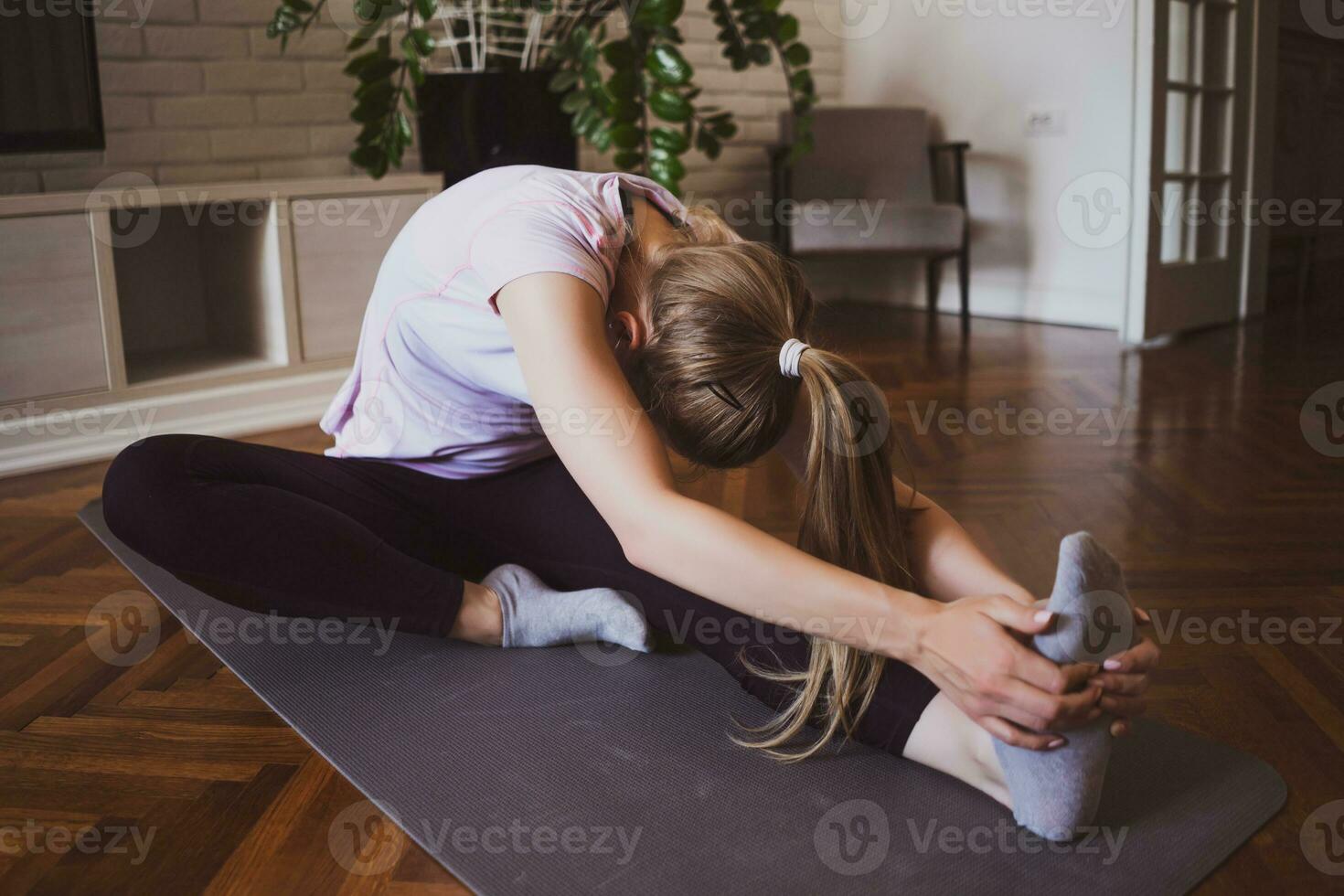 giovane donna praticante pilates e yoga esercizi a casa foto