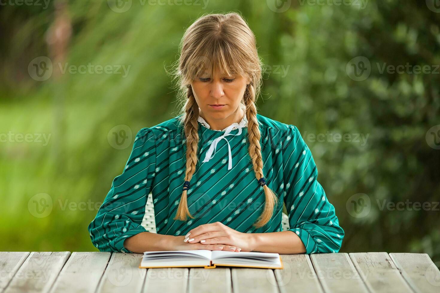 un' donna lettura a il tavolo foto