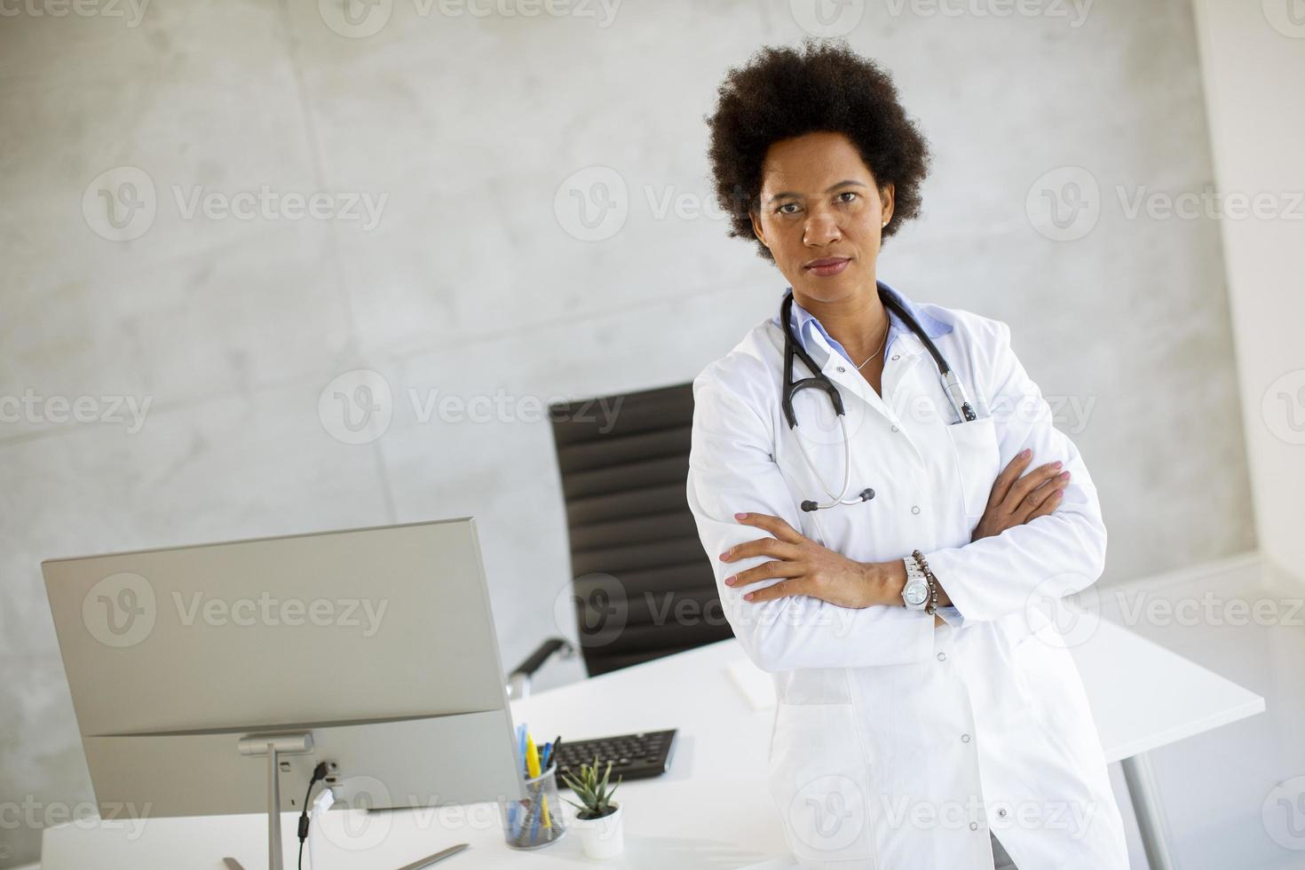 medico in un ufficio con le braccia conserte foto