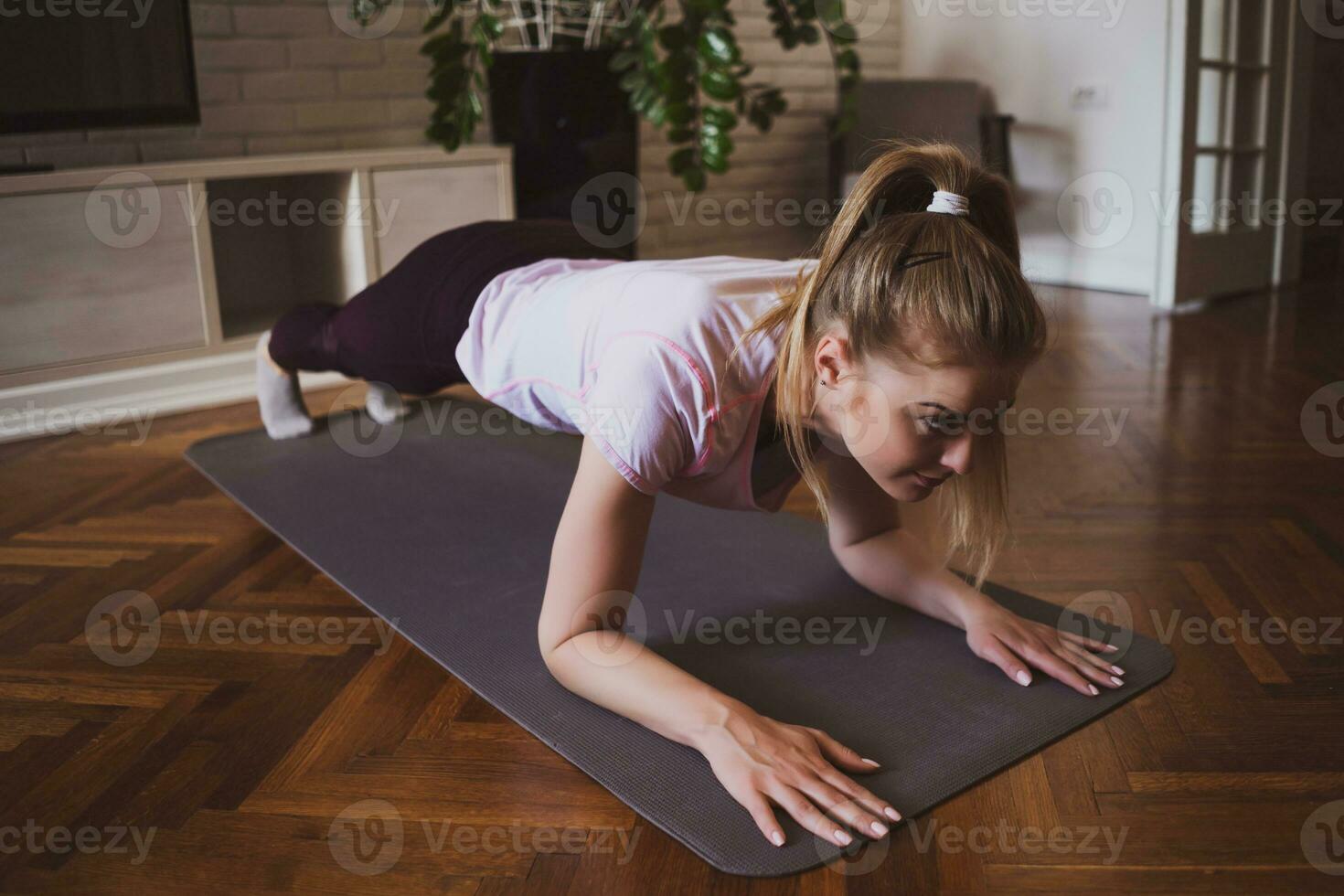 giovane donna praticante pilates e yoga esercizi a casa foto