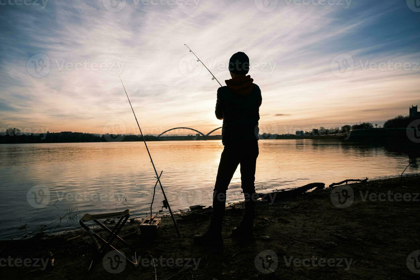 un' ragazzo è pesca su un' soleggiato giorno foto