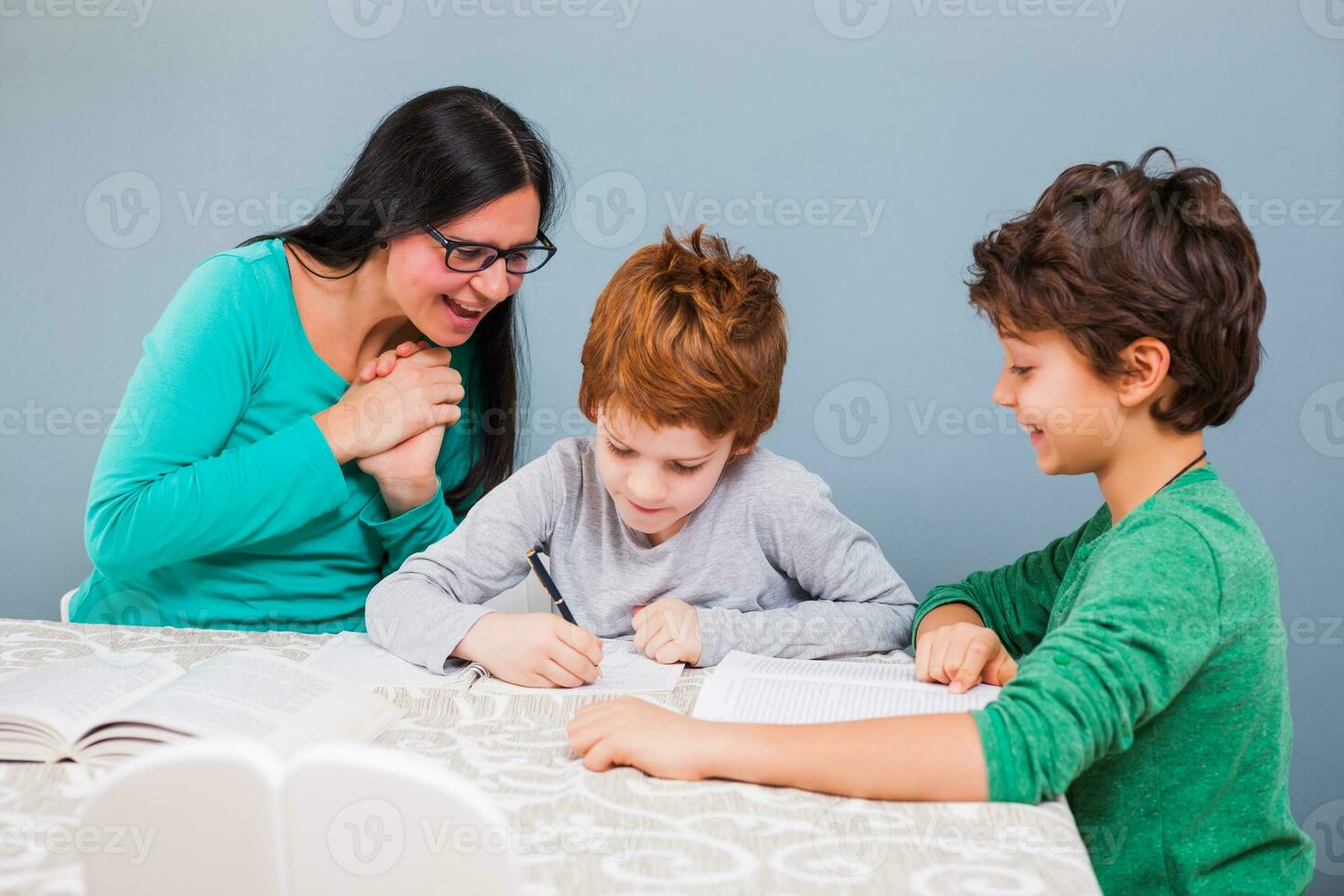 un' madre porzione sua bambini con il compiti a casa foto