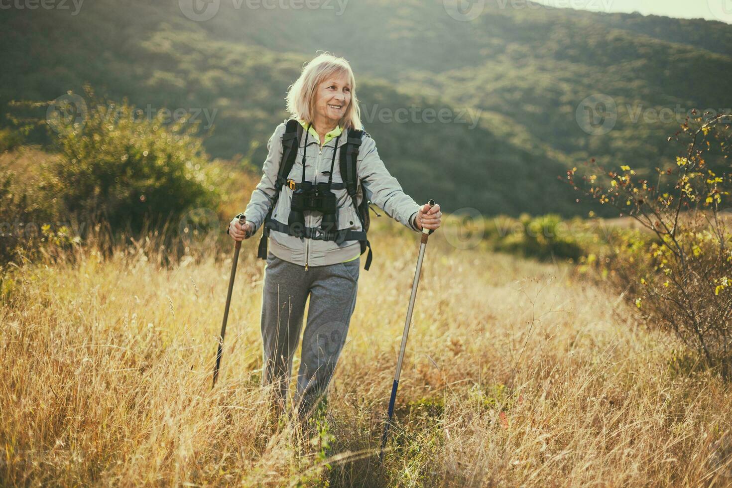 un' anziano donna escursioni a piedi foto