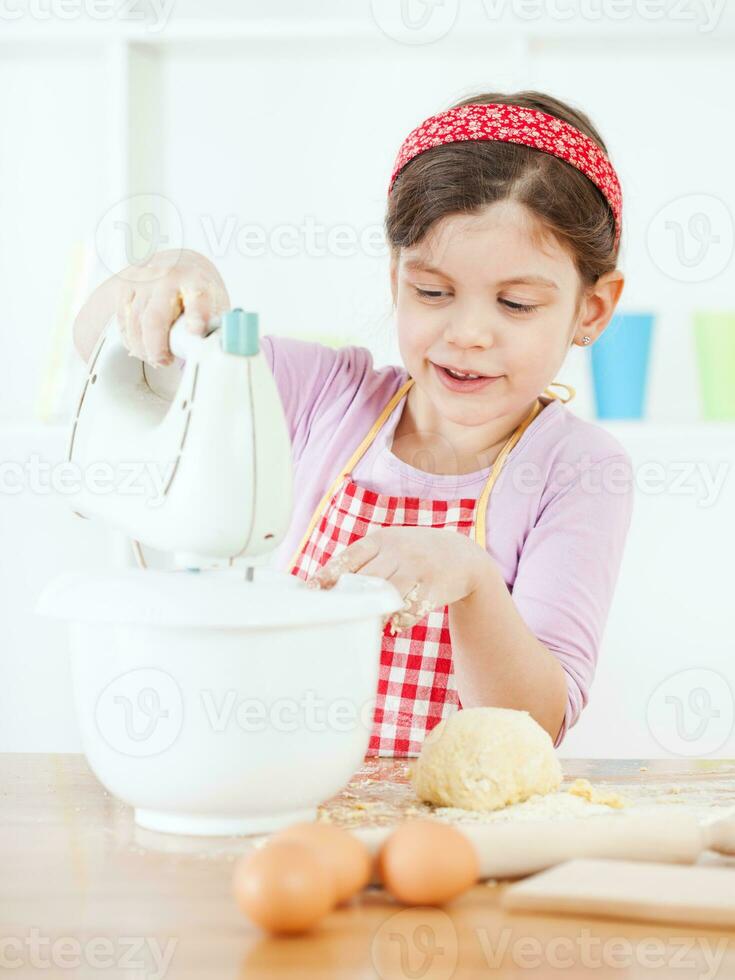 un' giovane ragazza cucinando foto