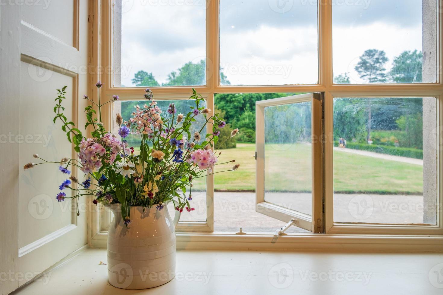 fiori e finestra con vista sui giardini da una tradizionale casa signorile inglese foto